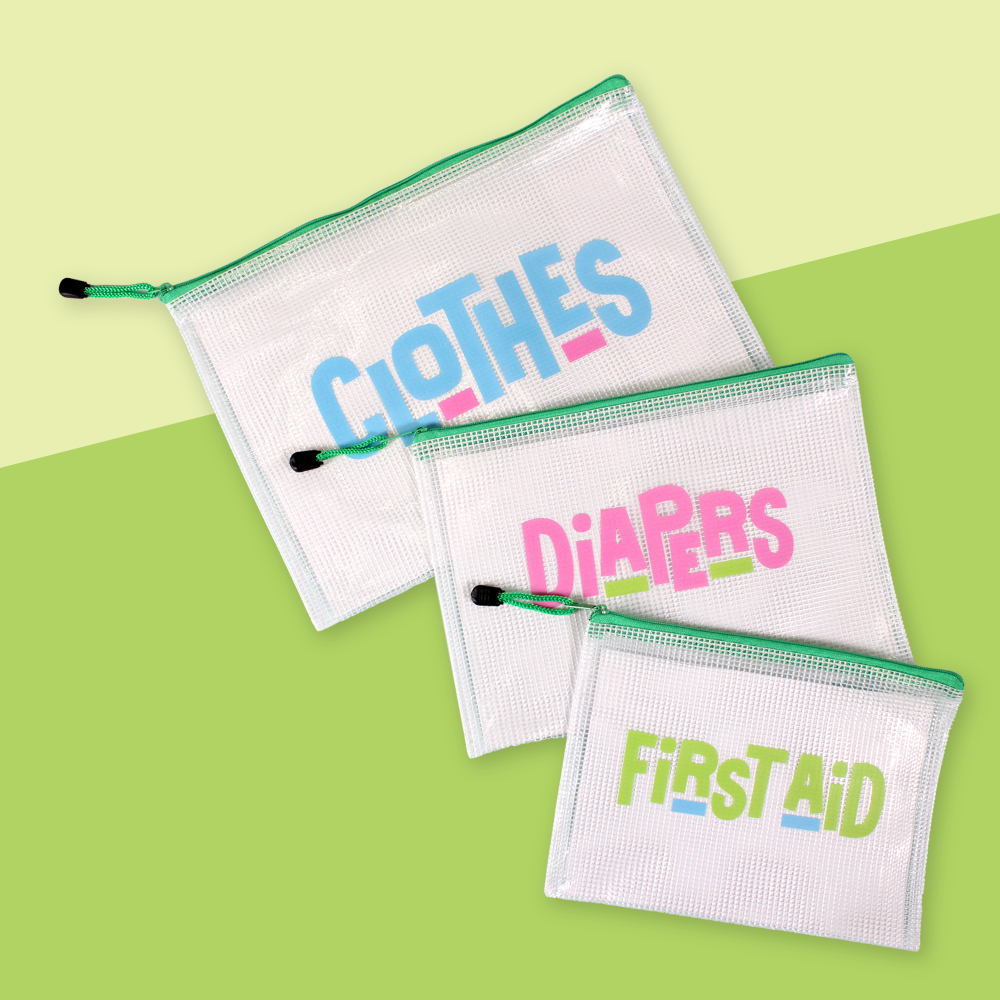 The InchBug 3-pack Diaper Bag Organizers placed on a green two-tone background, one marked 'CLOTHES', one 'DIAPERS', and one 'FIRST AID'.