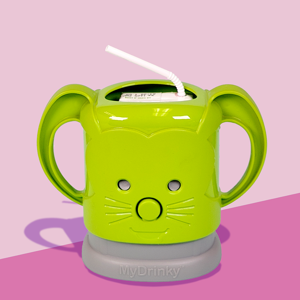A green InchBug MyDrinky adjustable juice box holder with a cartoon face and sturdy handles, attached to a grey base, designed to hold a juice box.