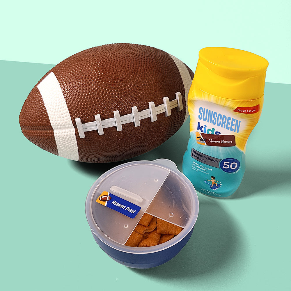 A collection of items including a football, a sunscreen bottle, and a container with labels showcasing different colors and text styles for personalized adhesive labels from InchBug.