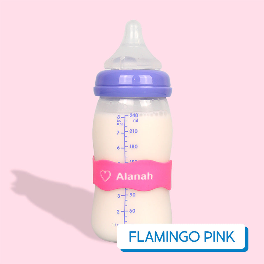 Baby bottle with pink InchBug Orbit Label on a pink background, labeled 'Flamingo Pink'.