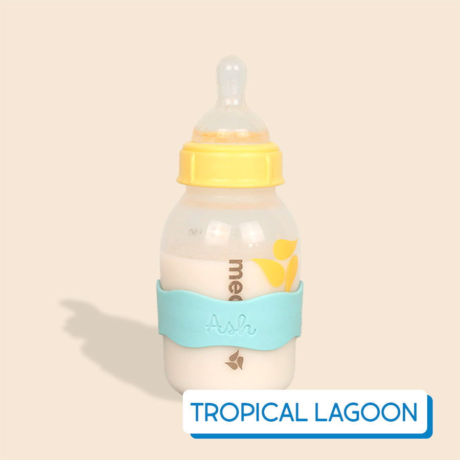 Baby bottle with blue InchBug Orbit Label on a beige background, labeled 'Topical Lagoon'.