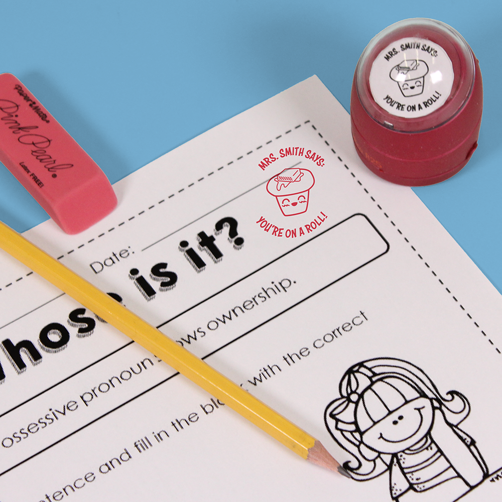 Red personalized teacher stamp with self-inking base, with a unique design featuring a teacher's name and a phrase 'You're on a roll!'.