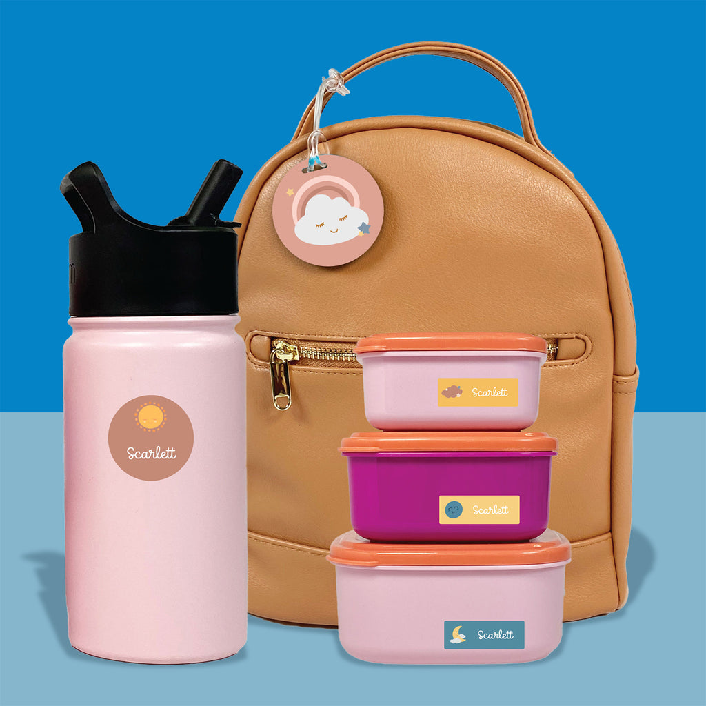 a yellow leather backpack, 3 stacked food containers, and a water bottle labeled with InchBug labels and bag tags in front of a two-toned blue background