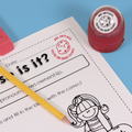Red personalized teacher stamp with self-inking base, with a unique design featuring a teacher's name and a phrase 'You're one smart cookie!'.