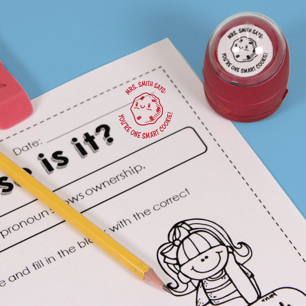 Red personalized teacher stamp with self-inking base, with a unique design featuring a teacher's name and a phrase 'You're one smart cookie!'.