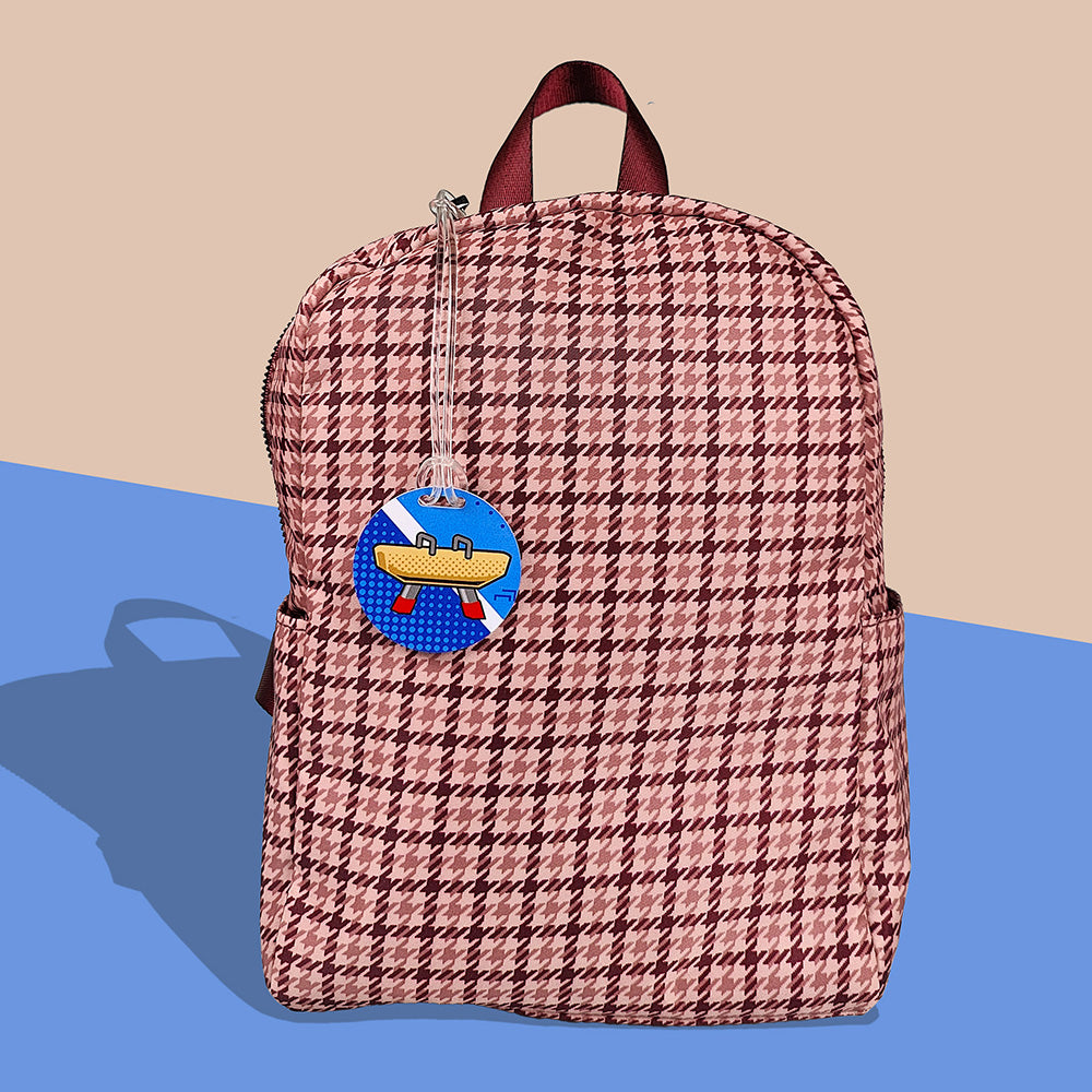 InchBug Sports Kids Circle Bag Tag attached to the zipper of a mesh-designed backpack. 