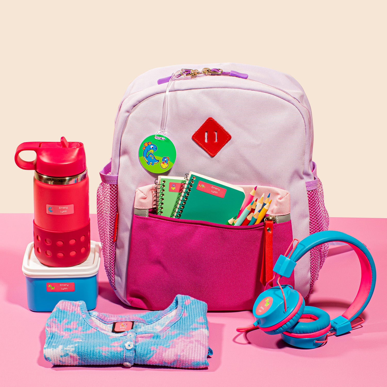 a pink bag, blue headphones, blue blouse with pink prints, red tumbler, and blue lunch container with white lid, all labeled with the inclusions of the InchBug Holiday Gifting Big Bundle Combo Pack