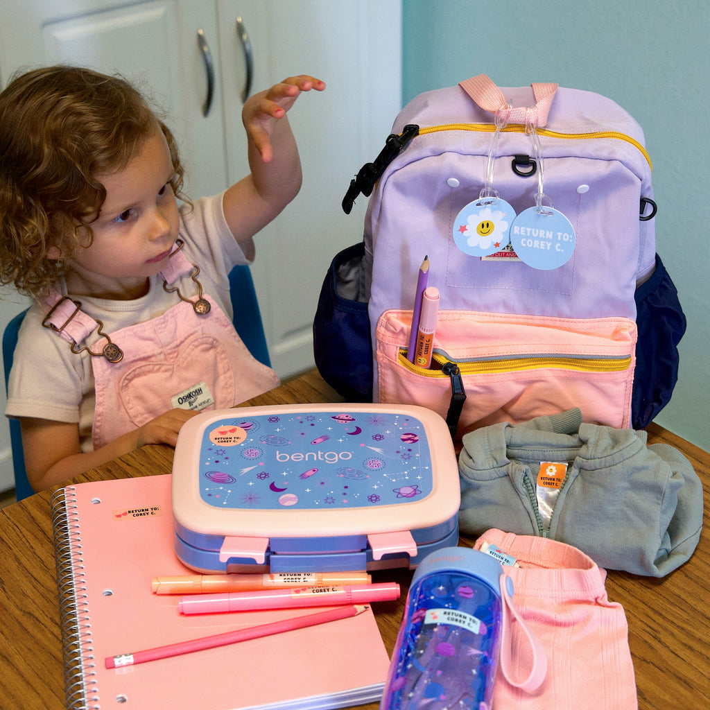 child with her belongings labeled with Big Bundle Daycare Labels Solid Combo Pack 