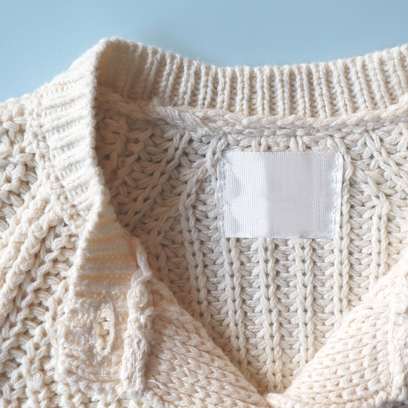 A close-up of a blue garment with an InchBug TagPal Kids clothing label tag