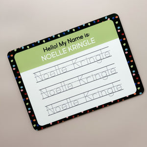 InchBug personalized handwriting board with Christmas light designs, text reads "NOELLE KRINGLE"; placed against a beige background