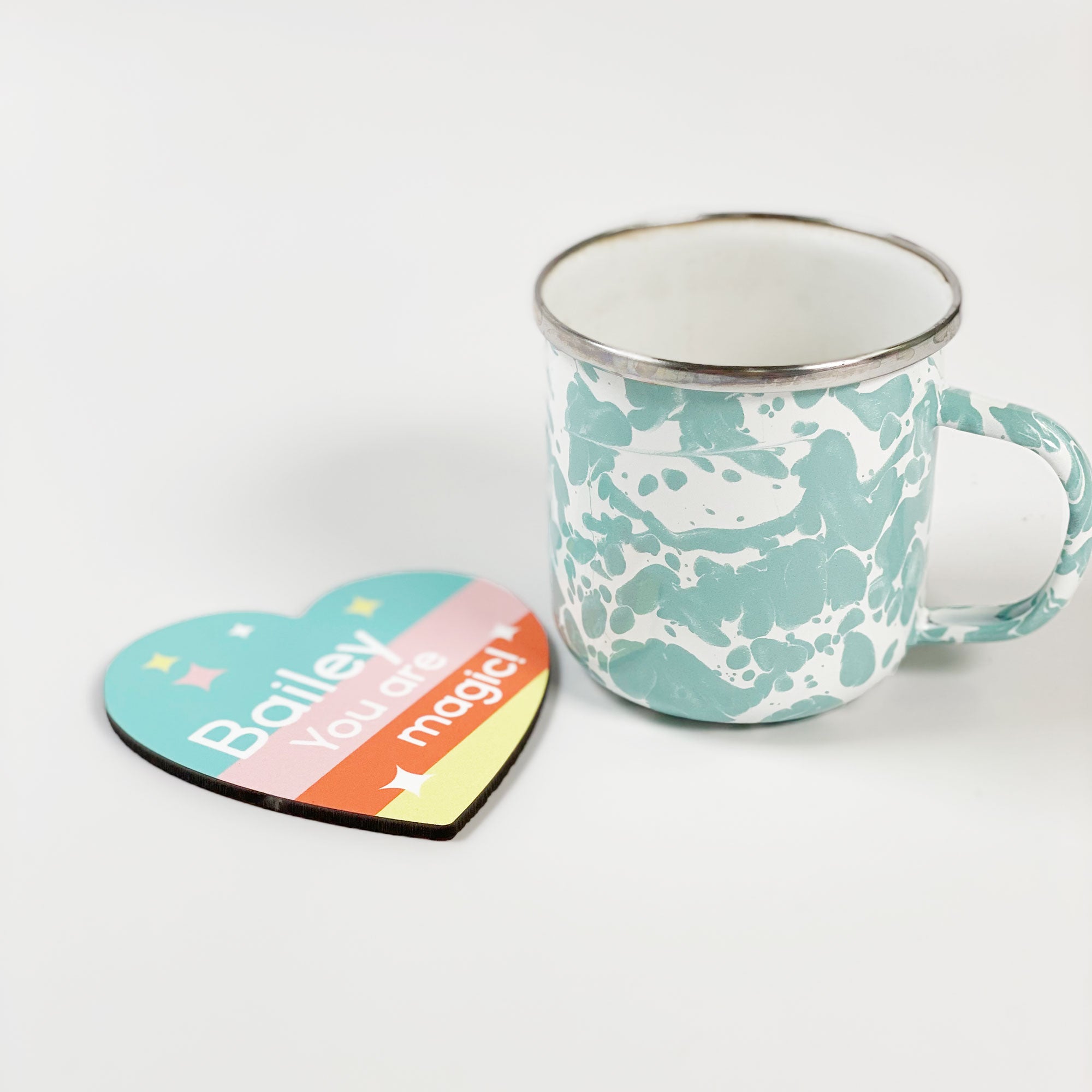 InchBug's heart-shaped coaster beside a ceramic mug