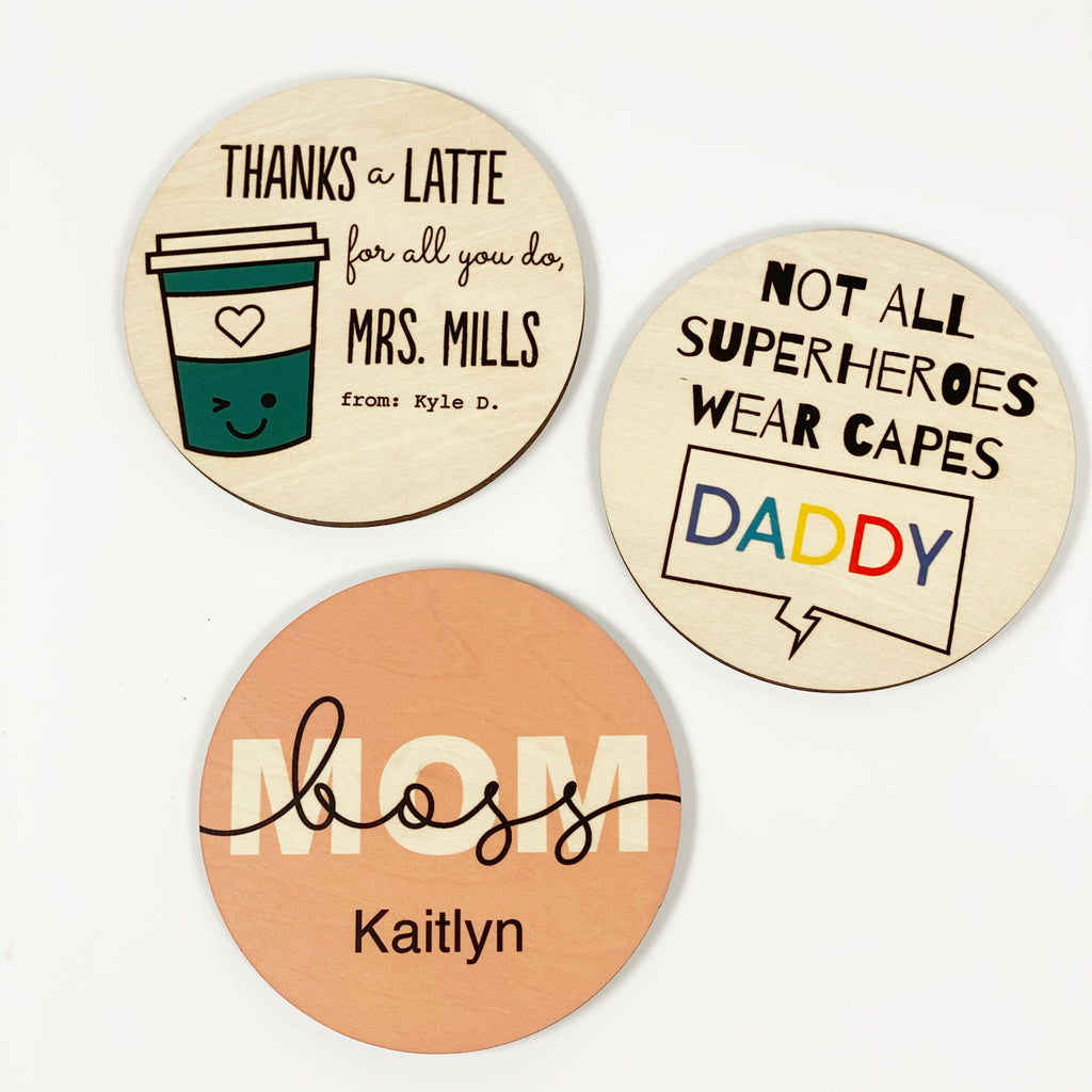 3 personalized circular coasters with different prints against a white background
