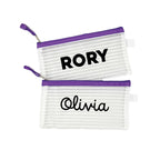 Two purple InchBug personalized zipper pouches with the names 'RORY' and 'Olivia' printed on them.