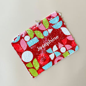 red sequin pouch with festive shapes and customized with the name 'Josephine' in white font color