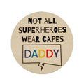 A personalized wooden coaster with the text 'NOT ALL SUPERHEROES WEAR CAPES Daddy' printed on it.
